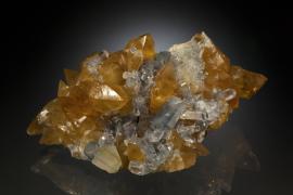 Celestine and calcite, Maybee, Monroe County, Michigan Celestine and calcite, Maybee, Monroe County, Michigan. Maybee produced some of the finest celestine specimens ever found in North America. This specimen is a particularly rare combination of celestine with golden calcite. Specimen 17 cm wide. Photo by J. Jaszczak and C. Stefano. (DM 25331)